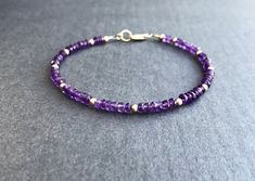 "Amethyst Bracelet Sparkling purple and gold....what's not to like? Genuine amethyst rondelles encircle this bracelet, which is interspersed with 14K gold filled beads. Lobster clasp closure with pretty rope detail ring at clasp. Fashioned on professional quality beading wire for strength and flexibility. A nice addition to your collection. You know -- the one that keeps growing. Unashamedly. Bracelet collectors unite! Faceted rondelles of genuine amethyst, about 3.5-4mm All components 14K gold Dainty Purple Beaded Bracelets With Round Beads, Dainty Purple Beaded Bracelet With Round Beads, Dainty Purple Beaded Bracelet, Dainty Purple Beaded Jewelry, Dainty Handmade Purple Bracelets, Purple Rondelle Beaded Bracelets As Gift, Adjustable Purple Rondelle Beaded Bracelets, Amethyst Beaded Bracelets With Spacer Beads As Gift, Beaded Amethyst Rondelle Jewelry