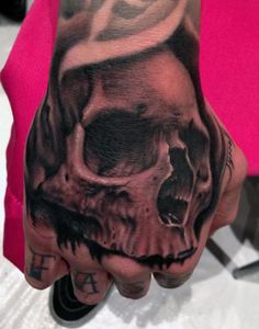 a hand with a skull and cross on it