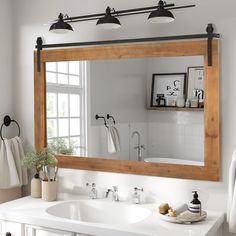 a bathroom with a sink, mirror and hanging lights