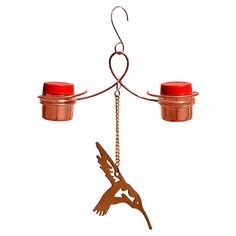 two red candles are hanging from a metal bird ornament on a white background