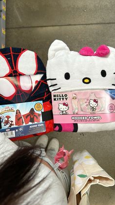 a hello kitty stuffed toy is being held up by someone's hand with the tag on it