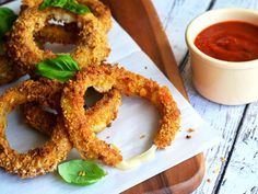 some onion rings on a cutting board with sauce