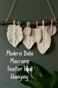 three white and pink feathers hanging from a branch with the words modern boho macrame feather wall hanging