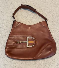 This classic Gucci Web Horsebit Hobo purse is brown leather with a great horsebit feature on the front. The leather strap measures 16 inches. The purse measures 13 1/2 x 10 1/2 inches. The interior of the purse is in pristine condition. There are a few small marks on the front of the purse- see photos. No dust bag, cards or receipt available. Please go to my shop- Carter Jewelry22- for more fabulous vintage and antique pieces! Also follow me on Instagram at CarterJewelry. Classic Brown Shoulder Bag With Horsebit Detail, Brown Saddle Shoulder Bag With Gold-tone Hardware, Brown Rectangular Shoulder Bag With Horsebit Detail, Rectangular Brown Shoulder Bag With Horsebit Detail, Designer Brown Shoulder Bag With Horsebit Detail, Brown Shoulder Bag With Horsebit Detail, Designer Satchel Shoulder Bag With Horsebit Detail, Business Satchel Shoulder Bag With Horsebit Detail, Brown Travel Bags With Horsebit Detail