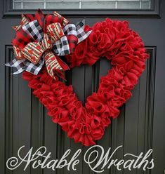 a heart shaped wreath is hanging on the front door