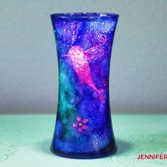 a blue glass vase with a pink fairy on it