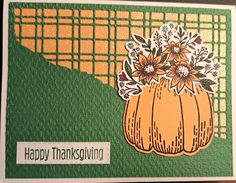 a happy thanksgiving card with an orange pumpkin and flowers on the front, sitting on a table