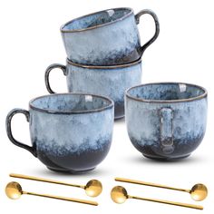 three blue and gold coffee mugs with spoons on the side, one is empty