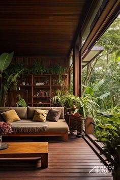 a living room filled with furniture and lots of plants on top of wooden flooring