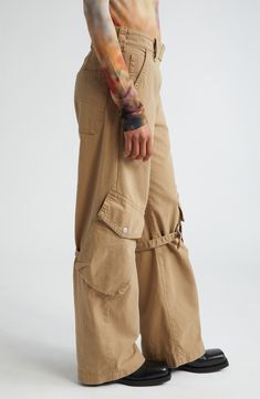 The label's knack for juxtaposing exquisite tailoring with eclectic details shines in these canvas pants featuring off-kilter cargo pockets with belted accents. 31 1/2" inseam; 21" leg opening; 11" front rise; 14 1/2" back rise (size 34EU) Exposed zip fly with snap-tab closure Front slant pockets; back patch pocket; cargo flap-patch pockets Adjustable D-ring belts at knees 100% cotton Machine wash, line dry Imported Designer Clothing Utility Pants With Belt Loops, Khaki High Waist Cargo Jeans, Khaki High-waist Parachute Pants With Belt Loops, Beige High Waist Utility Cargo Jeans, Fitted Utility Cargo Pants With Belt Loops, Utility Pants With Belt Loops For Fall, Cotton Parachute Pants With Belt Loops For Fall, Fall Cotton Parachute Pants With Belt Loops, Beige High Waist Cargo Jeans