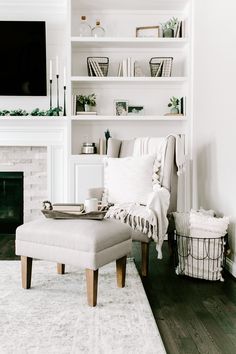 a living room with white furniture and a fireplace