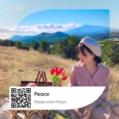 a woman sitting on top of a grass covered field next to a basket filled with flowers