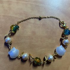 Handmade Gold Seashell Bracelet Gold Bracelets With Lobster Clasp For Vacation, Gold Bracelet With Lobster Clasp For Vacation, Elegant Metal Bracelets For Beach, Elegant Handmade Bracelets For Vacation, Elegant Gold Bracelets For Vacation, Elegant Vacation Jewelry With Lobster Clasp, Gold Beaded Charm Bracelet For Beach, Blue Metal Bracelets For Beach, Adjustable Metal Bracelet For Vacation