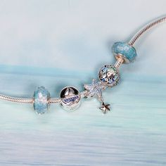 This is charm only, bracelet is sold separately.Experience the beauty of the ocean with our mesmerizing Blue Starfish dangle bead charm for a bracelet. This enchanting charm, crafted from solid 925 sterling silver and featuring a platinum platting and oxidation process, showcases a delicate starfish design with sparkling cubic zirconia and a charming little dangle. As you wear it, let the calming waves and limitless potential of the sea inspire your every step. Add a touch of elegance and marine Ocean-inspired Silver Charms Jewelry, Celestial Silver Charm Bracelet, Silver Star-shaped Jewelry With Dangling Charms, Silver Starfish Charm For Gifts, Silver Starfish Charm As Gift, Silver Starfish Charm For Gift, Silver Star Charm With Celestial Style, Silver Star Charm Celestial Charms, Silver Star Charm Celestial