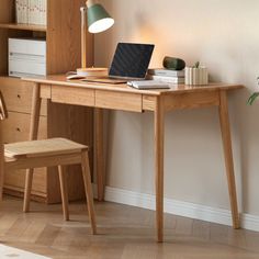 a laptop computer sitting on top of a wooden desk in front of a book shelf