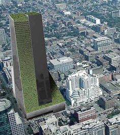 an aerial view of a city with tall buildings and green grass covering the top part