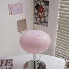 a pink lamp sitting on top of a white table