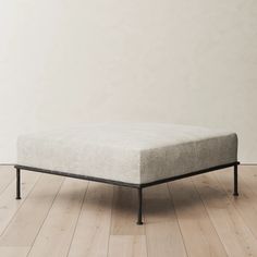 a mattress sitting on top of a wooden floor next to a white wall and wood floors