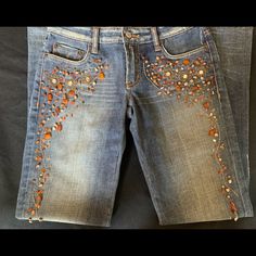 the jeans are decorated with orange and gold beads