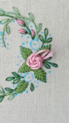 a close up of a piece of cloth with flowers and leaves embroidered on the fabric