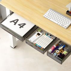 an office desk with two drawers and a keyboard on the top, along with other items