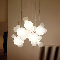 a chandelier hanging from the ceiling in a room with people looking at it