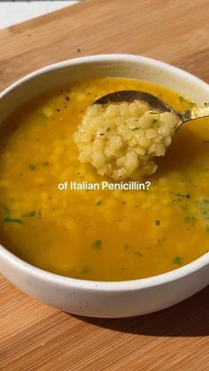 a spoon full of soup on top of a wooden table