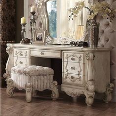 an antique white dressing table with mirror and stool