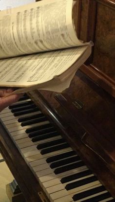 an open book sitting on top of a piano