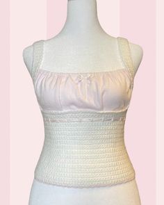 a mannequin wearing a white top with ruffles on the bust and bottom