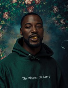 a man in a green hoodie with the words the blacker the berry on it