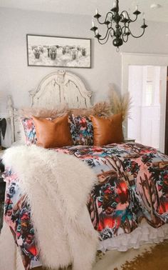 a bedroom with a bed, chandelier and pictures on the wall above it