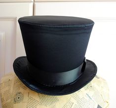 This simple and elegant victorian inspired top hat is covered in a beautiful black satin with a gentle shine .It is finished off with matching colored ribbon around the crown. Need this TOP HAT in another color? with more decoration? Just send me a message to talk about a custom hat made just for you! This hat is fully lined with satin and it is made to according to your exact head measurement making it suitable for both men and women who want a bit more on their head than a mini hat! IMPORTANT Gothic Fitted Brimmed Top Hat, Fitted Gothic Brimmed Top Hat, Fitted Brimmed Top Hat For Costume Party, Gothic Fitted Top Hat With High Crown, Gothic Top Hat With High Crown, Gothic High Crown Top Hat, Victorian Top, Elizabethan Collar, Steampunk Top