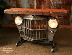 an old car made out of metal and wood with two lights on it's head