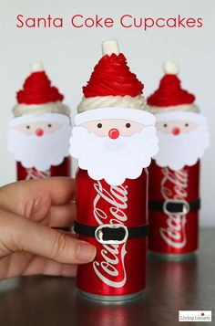 three coca - cola cans with santa claus faces on them