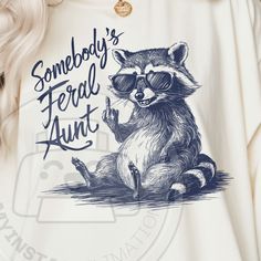 a woman wearing a white shirt with a raccoon on it