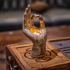 a wooden box with an intricate design on it and a candle holder in the shape of a hand