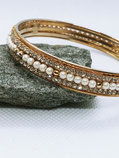 Description: Gold Tone Pearl and Rhinestone Metal Bangle Bracelet / Sparkly Bangle for Her / Seed Pearls and Clear Rhinestones Wrapped on Gold tone Metal Brand: Unbranded Color: Gold tone Condition: Good Vintage condition, some wear from normal use Bead types: pearls and rhinestones Closure style: no closure bangle slip on Measurements: 6.5 cm across 1 cm wide Follow me on: Ebay:  https://www.ebay.ca/usr/kittyskreations1 Etsy shop: https://www.etsy.com/ca/shop/BlkkittyGifts Wedding Jewelry Simple, Unicorn Pendant, Silver Wedding Jewelry, Pearl Jewelry Wedding, Gold Wedding Jewelry, The Bangles, Metal Bracelet, Bridesmaid Bracelet, Bridal Bracelet