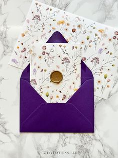 two envelopes with flowers on them, one has a button