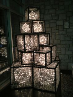 a stack of cubes with lights on them in front of a window at night