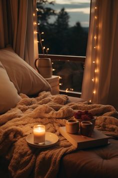 two teacups on a tray sitting on a bed with lights in the background