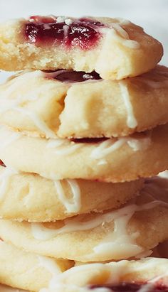 a stack of cookies sitting on top of a white plate covered in frosting and jelly