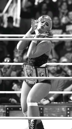 a woman standing on top of a wrestling ring