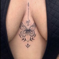 a woman's breast with a butterfly tattoo on her chest and an arrow in the middle