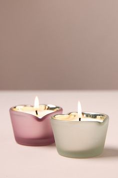 two small candles sitting next to each other on a table