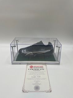 a pair of shoes is in a clear case with an award plaque next to it