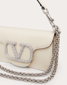 Valentino Garavani Locò small shoulder bag in calfskin with VLogo Signature element adorned with Swarovski® crystals. Equipped with both a detachable sliding chain strap and a detachable handle, this accessory can be worn as a crossbody/shoulder bag or used as a handbag. - Tone-on-tone finish hardware - Magnetic closure - Removable leather handle - Shoulder strap with removable sliding chain - Nappa leather lining. Interior: one slip pocket Shoulder strap drop length: 55 cm / 21.7 in. - Dimensio Logo Woman, Jewel Logo, Studded Sneakers, Oxford Boots, Belt Jewelry, Valentino Bags, Boutique Online, Small Shoulder Bag, Boots For Sale