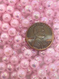 a penny sitting on top of pink beads