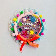 craft punk badge with pom - poms and stars on it's side