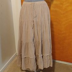 a woman's skirt is on display in front of a wooden door with a mirror behind it